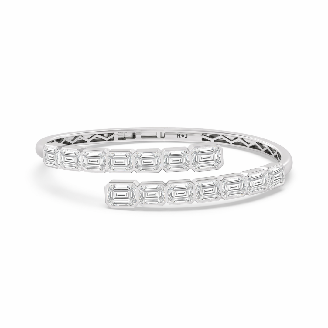 Emerald cut diamond bypass bangle bracelet in 18K white gold with bezel setting and lattice interior