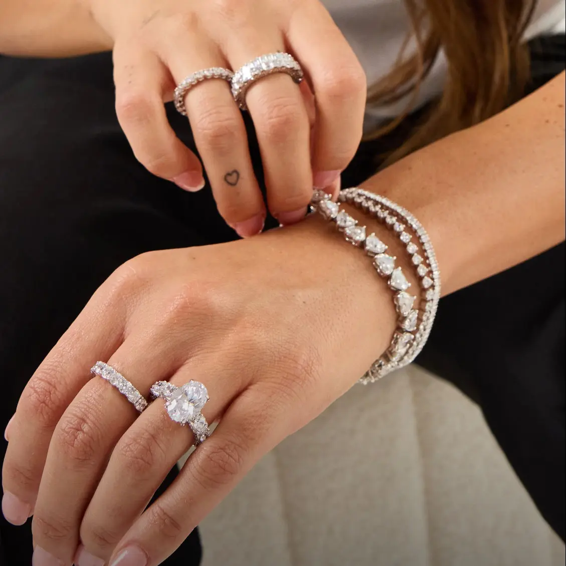 Custom diamond engagement ring stack with matching tennis bracelets in solid white gold
