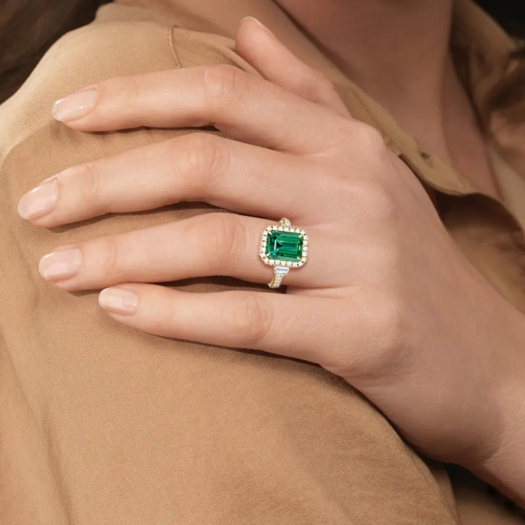 Custom emerald cut green emerald halo ring in solid yellow gold with diamond accents