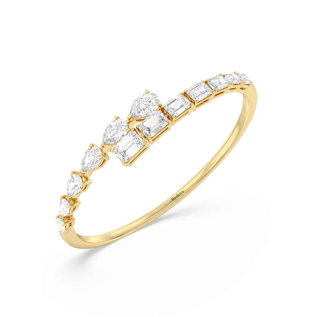 pear and emerald cut diamond bangle in 14k yellow gold, angled view of the bypass front