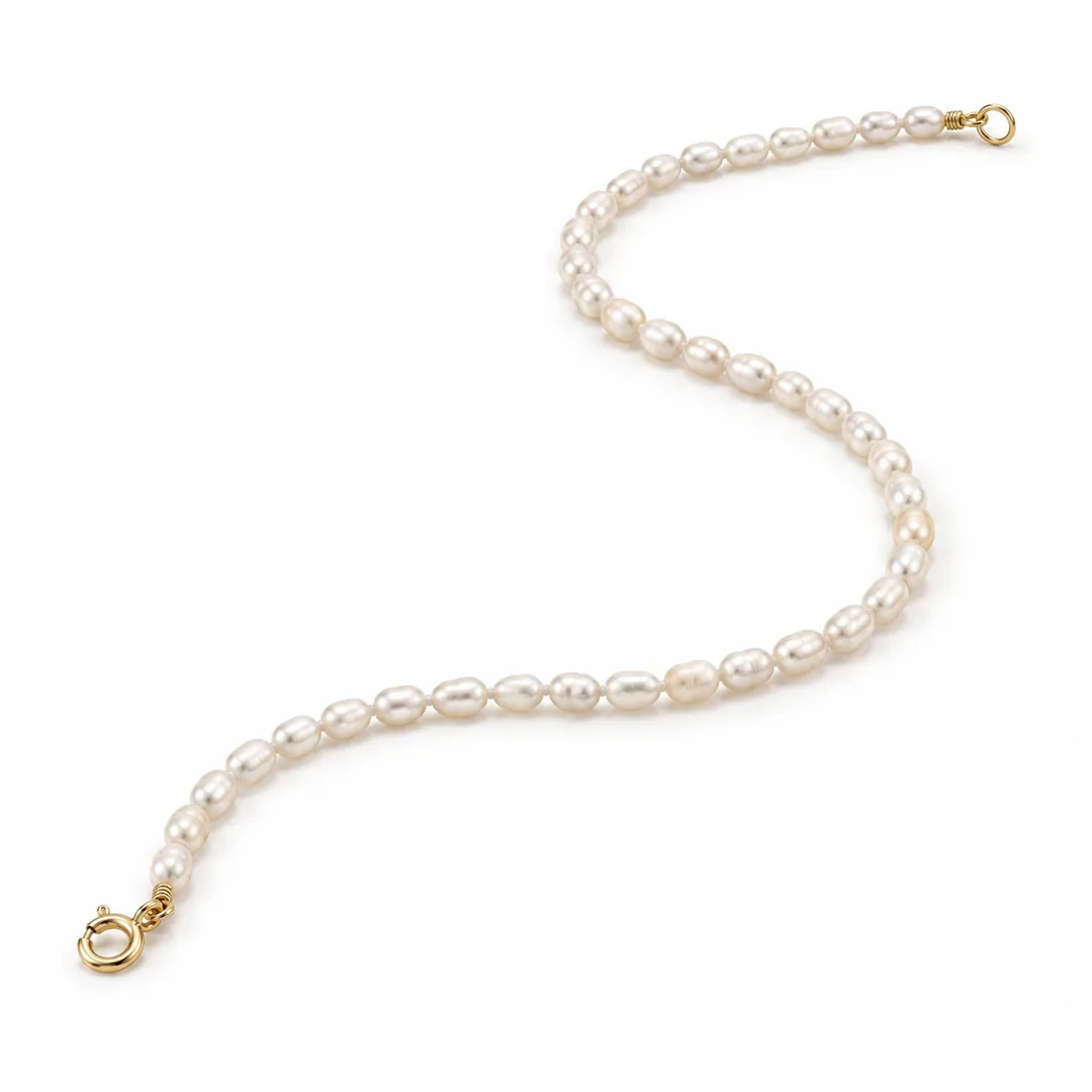 petite cultured pearl beaded bracelet with irregular oval beads and a yellow gold spring-ring clasp, unfastened in a curved arrangement on white, AI styling image